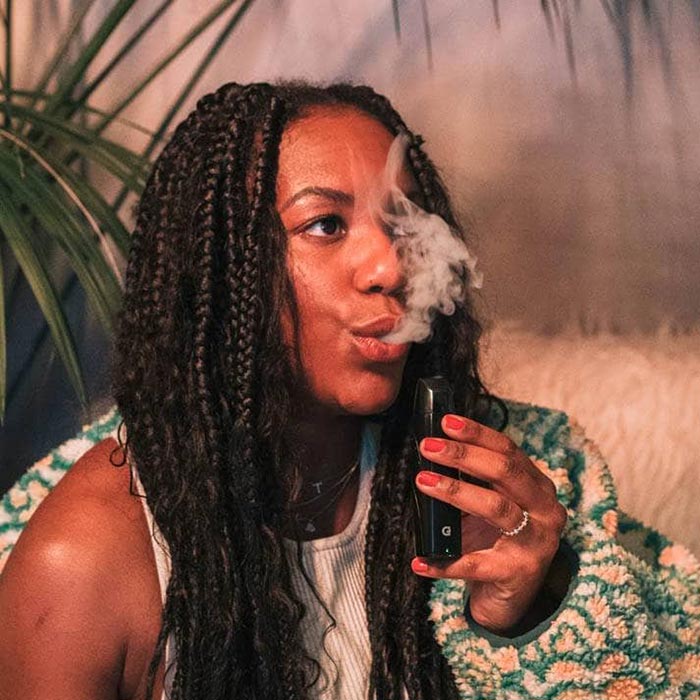 Woman with braided hair holding an G Pen Elite 2 vaporizer NZ