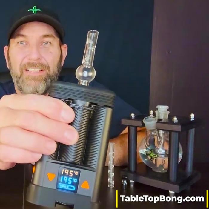 Lee from TableTopBong.com holding a Mighty+ Vaporizer with a Clear Globe Glass Stem